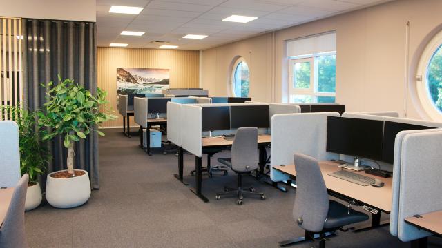 Adskil skriveborde i et åbent kontorrum ved hjælp af bordskærme i stof og rumdelere i naturlige materialer