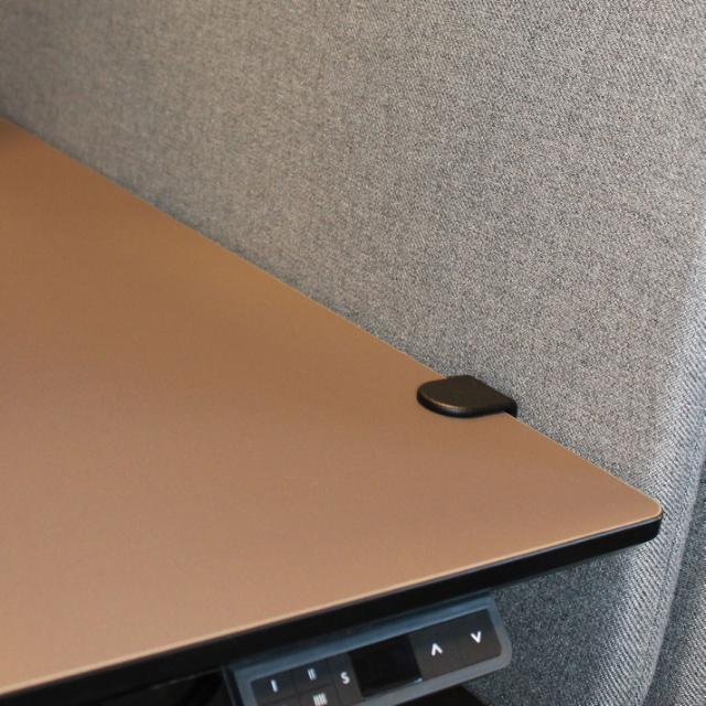 Hæve sænkeskrivebord her med en flot brun linoleumsbordplade og grå akustik bordskærm