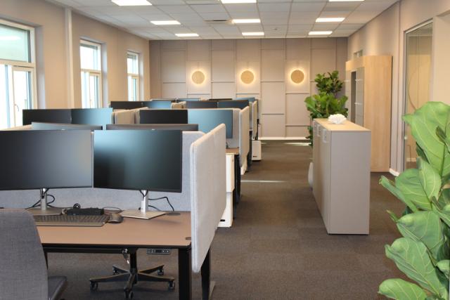 Kontorindretning i brune varme farver og med flot dekorativ LED belysning indbygget i panelvæg