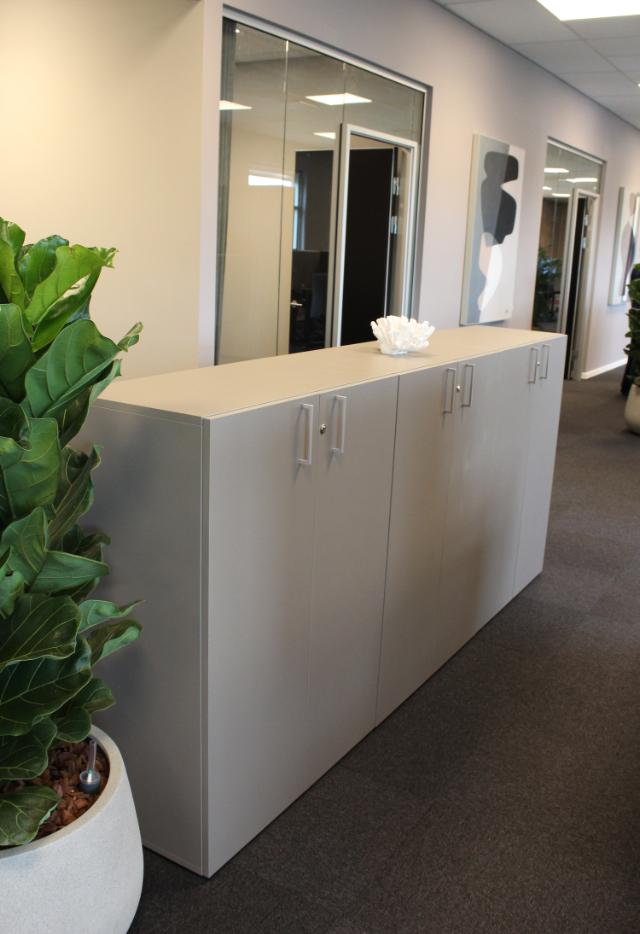 Opbevaring med flotte stilrene skabe i storrumskontoret giver struktur og orden på arbejdspladsen