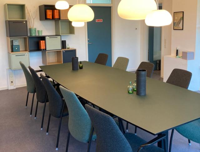Svævende skulpturelle pendler over mødebordet giver både et smukt lys men sætter stemningen i lokalet.