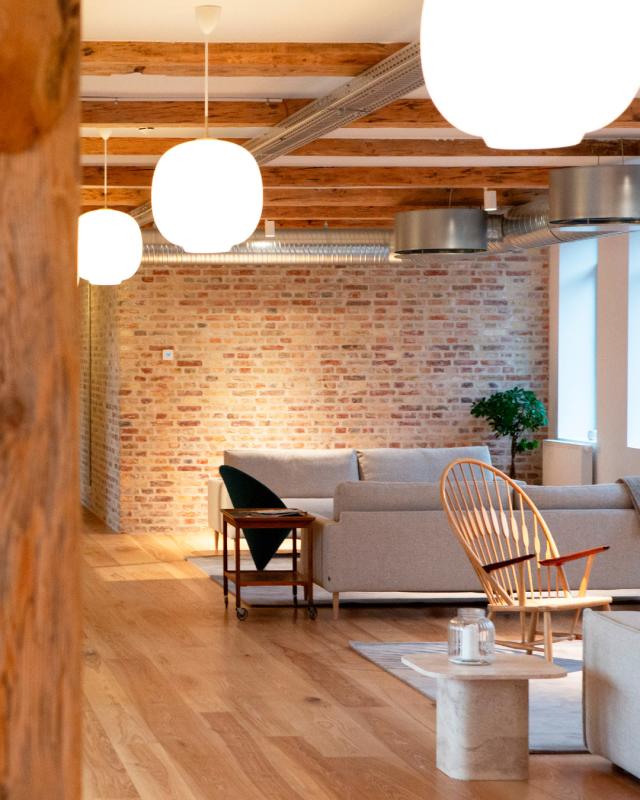 Belysningen i venterummet er her varm og indbydende med Radiohus pendler på række fra Louis Poulsen