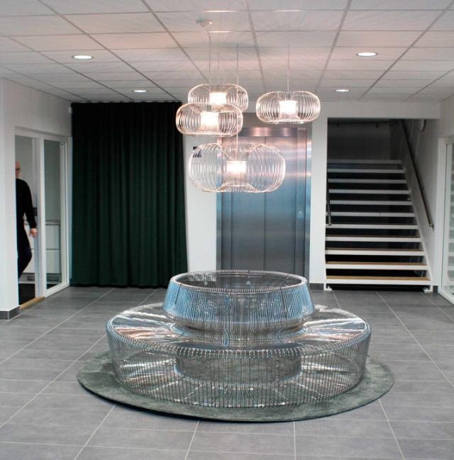 Indretning af indgang og reception med bænk udformet i smuk metal