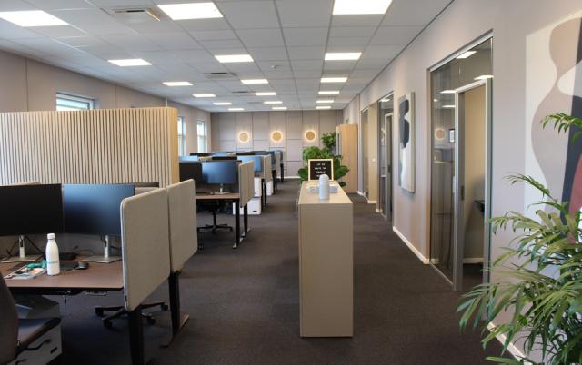 Kontor indrettet i varme farver og med materialer som egetræ, linoleum og gardiner giver en god stemning på arbejdpladsen.